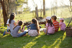 Children barbecueing sausages, Munsing, Bavaria, Germany