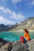 Woman looking over reservoir Finstertal, Sellrain, Stubai Alps, Tyrol, Austria