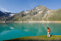 Female hiker at Finstertal reservoir, Sellrain, Stubai Alps, Tyrol, Austria