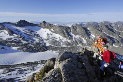 Drei Bergwanderer genießen Aussicht am Hochfeiler, Zillertaler Alpen, Südtirol, Italien