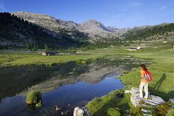 Woman standing at lake Gruensee, Fanesalm, Naturpark Fanes-Sennes-Prags, Dolomites, Trentino-Alto Adige/South Tyrol, Italy