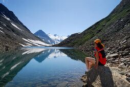 Woman looking over mountain lake, Passo del Corno Gries, Ticino Alps, Canton of Ticino, Switzerland