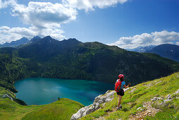 Woman hiking above reservoir Lago Ritom, Ticino Alps, Canto of Ticino, Switzerland