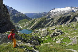Female hiker looking over Lago Bianco to Basodino glacier, Ticino Alps, Ticino, Switzerland