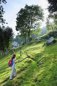 Frau beim Bergwandern, Almhütte im Hintergrund, Monti Lariani, Comer See, Lombardei, Italien