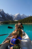 Family in paddle boat, Moraine Lake, Banff National Park, Alberta, Canada