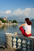 Frau blickt über Comer See auf Tremezzo, Lombardei, Italien