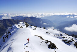 Frau beim Gipfelkreuz des Monte Vioz, Ortlergruppe, Trentino-Südtirol, Italien