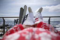 Young woman sunbathing on the terrace, skiing, Flims, Crap Sogn Gion, Grisons, Switzerland