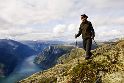 Junge Frau wandert mit Blick auf den Aurlandsfjord, Prest, Aurland, Sogn og Fjordane, Norwegen, Skandinavien, Europa