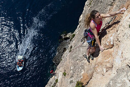Eine junge Frau und ein junger Mann klettern an den Klippen der Bucht von Zurrieq, Malta, Europa