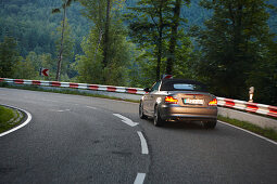 Convertible passing bendy road in the evening, Black Forest, Baden-Wuerttemberg, Germany