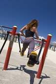 Eine Frau trainiert an einem Sportgerät am Strand, Tel Aviv, Israel, Naher Osten