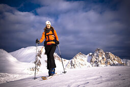Skitourengeherin mit Eisengabelspitze und Antonispitze im Hintergrund, Pareispitze, Dolomiten, Trentino-Südtirol, Italien