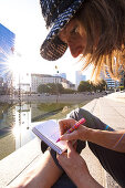 Woman writing a postcard, La Defense, Paris, France