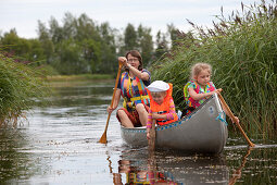 Eine Frau und zwei Mädchen, Kinder in einem Kanu auf der Insel Norrbyskär, Västerbotten, Schweden, Europa