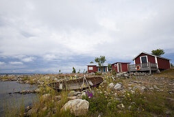 Cottages and rowing boat on the waterfront, island Stora Fjaederaegg, Vaesterbotten, Sweden, Europe