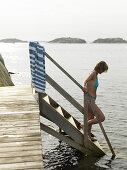 Woman bathing from bridge deck, Bohuslän, Sweden