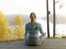 Woman meditates on terrace, Skane, Sweden