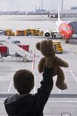 Boy holding a teddy bear, Munich airport, Bavaria, Germany