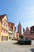 Fountain in front of a row of houses and Woernitztor city gate, Dinkelbuehl, Bavaria, Germany