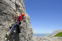 Frau klettert an Felswand, nahe Rifugio Rossi, Pania della Croce, Toskana, Italien