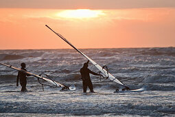 Two windsurfers in sunset light, St Peter-Ording, Schleswig-Holstein, Germany
