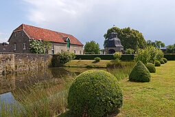 View across the moat towards pavilion and boxtrees, Gesmold Estate, Gesmold, Meller, Lower Saxony, Germany