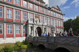 Entrance to Wolfenbüttel castle, now a secondary school, pupils sitting on the bridge, Wolfenbüttel, Lower Saxony, Germany