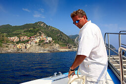 Boatswain with rope, landing at Manarola, boat trip along the coastline, Cinque Terre, Liguria, Italian Riviera, Italy, Europe