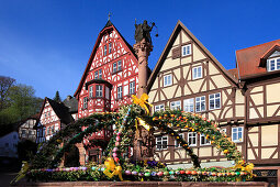 Fountain decorated with Easter eggs at the Schnatterloch, half-timbered houses at the market place, Miltenberg, Main river, Odenwald, Spessart, Franconia, Bavaria, Germany