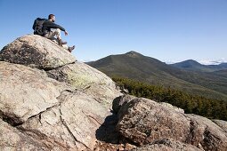 A hiker takes in the views from the summit of Mount Liberty during the summer months  Located in the White Mountains, New Hampshire USA