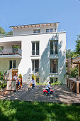 Mutter und zwei Kinder auf der Terrasse von einem Einfamilienhaus, Hamburg, Deutschland