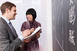 Chinesischlehrerin und deutscher Geschäftsmann an einer Tafel, Konfuzius-Institut Leipzig, Leipzig, Sachsen, Deutschland