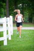 30 Jahre alte blonde Frau joggt in Trainingskleidung