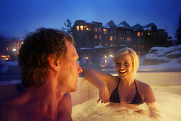 Woman and man bathing in outdoor pool, Four Seasons Resort Whistler, Whistler, British Columbia, Canada