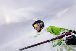 Freeskier liegt im Tiefschnee, Mayrhofen, Zillertal, Tirol, Österreich