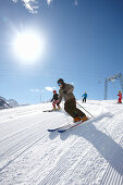 Vater und Kindern fahren Ski auf frisch präparierter Piste, Schlößlelift, Hirschegg, Kleinwalsertal, Vorarlberg, Österreich