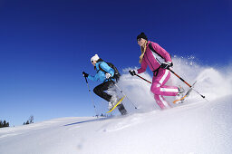 Young women snowshoeing, Hemmersuppenalm, Reit im Winkl, Chiemgau, Upper Bavaria, Bavaria, Germany, Europe