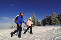 People hiking on winter hiking trail in snowy landscape, Hemmersuppenalm, Reit im Winkl, Chiemgau, Bavaria, Germany, Europe