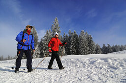 Menschen wandern auf Winterwanderweg in verschneiter Landschaft, Hemmersuppenalm, Reit im Winkl, Chiemgau, Bayern, Deutschland, Europa