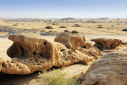 Bizarre Winderosion an Felsen mit Blick auf Savanne, Namibwüste, Namib, Namibia
