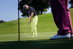 Two men playing golf, Prien am Chiemsee, Bavaria, Germany