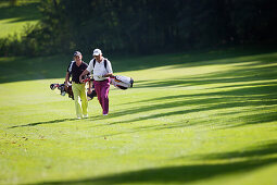 Two men playing golf, Prien am Chiemsee, Bavaria, Germany