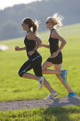 Two female runners on path near Munsing, Upper Bavaria, Germany