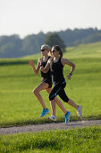 Two female runners on path near Munsing, Upper Bavaria, Germany