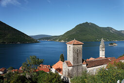 Blick auf Kirche Sveti Nikola mit Glockenturm, im Hintergrund Insel Gospa od Skrpjela, Perast, Bucht von Kotor, Montenegro, Europa
