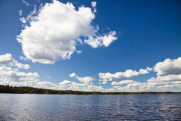 Blue sky with white clouds over Boasjön lake, Smaland, South Sweden, Scandinavia, Europe