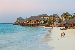 Menschen am Strand und Z Hotel in der Abenddämmerung, Nungwi, Sansibar, Tansania, Afrika