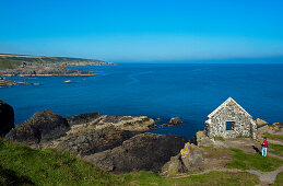 Tourist an einer Ruine oberhalb des Hafens von Portsoy, Aberdeenshire, Schottland